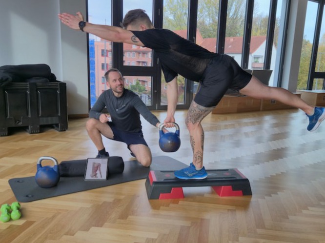Jakob Essen, Physiotherapeut & Personal Trainer, demonstriert Übung neben Patient in Pegeia & Paphos